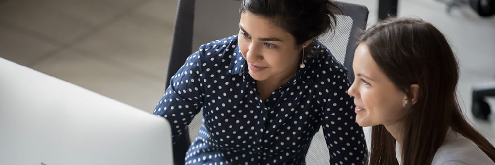 Interns working together at a desk.